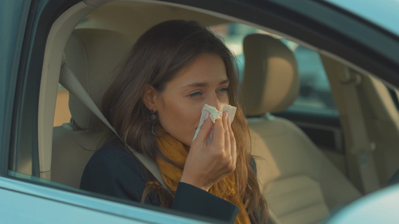 Woman Blowing Nose In Car