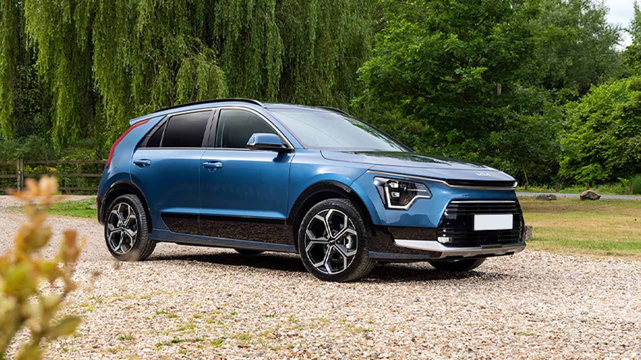 Blue Kia Niro parked in countryside, on a gravel driveway