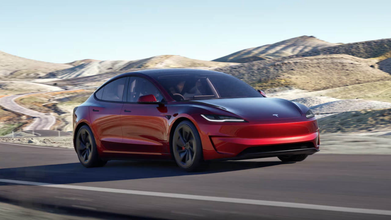 Red Tesla Model 3 Driving On Road