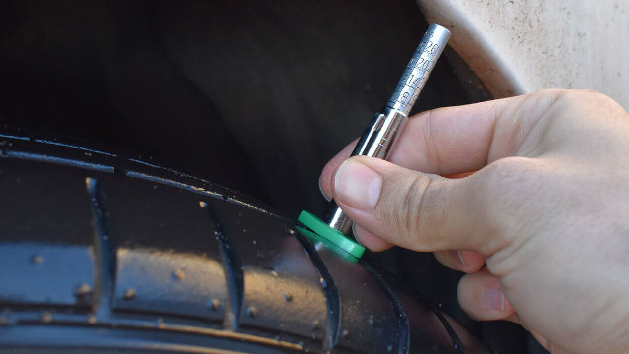 Someone checking tyre tread depth