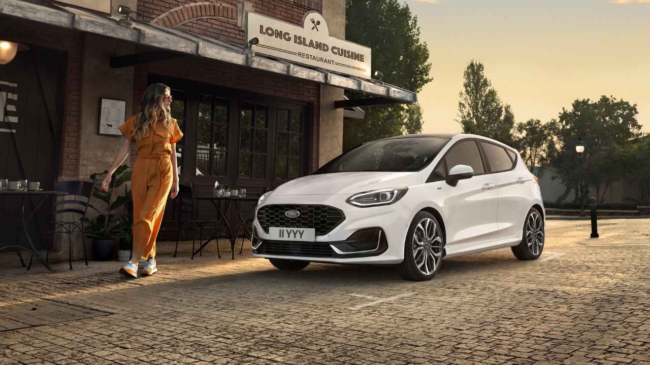 White Ford Fiesta parked in front of a wall window building