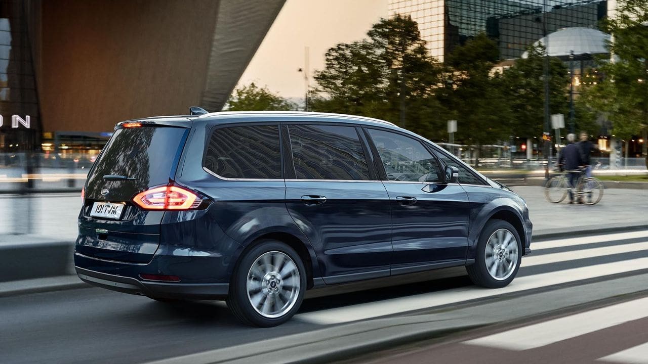 Side of a blue Ford Galaxy driving on the road