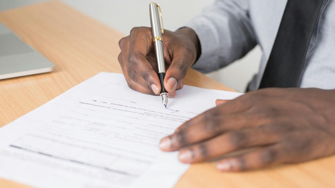 Man signing a contract on a table