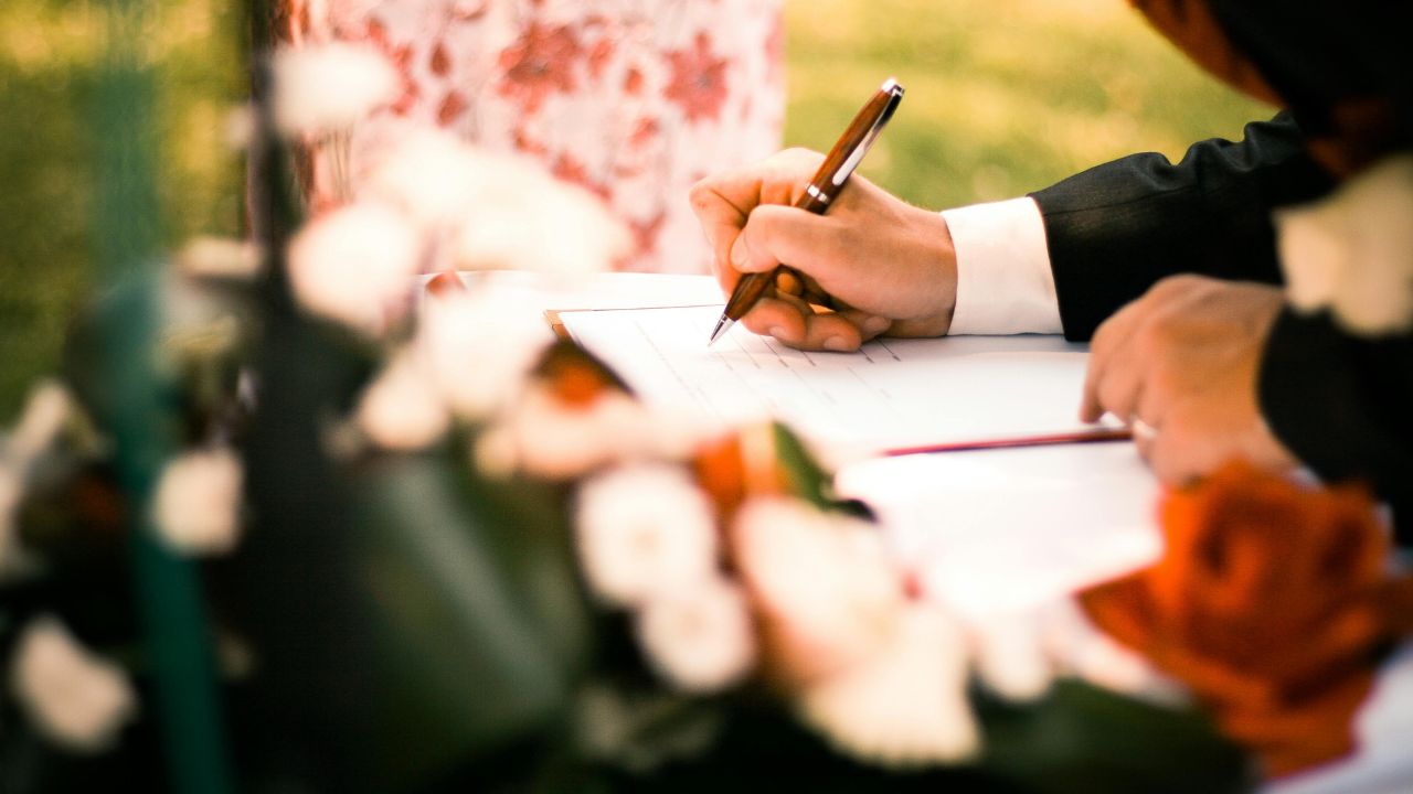 Man signing a contract on a table with flowers