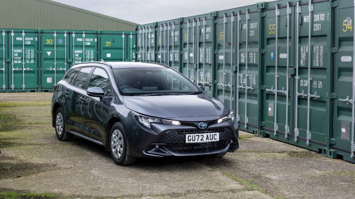Grey Toyota Corolla Commercial outside with shipping containers behind