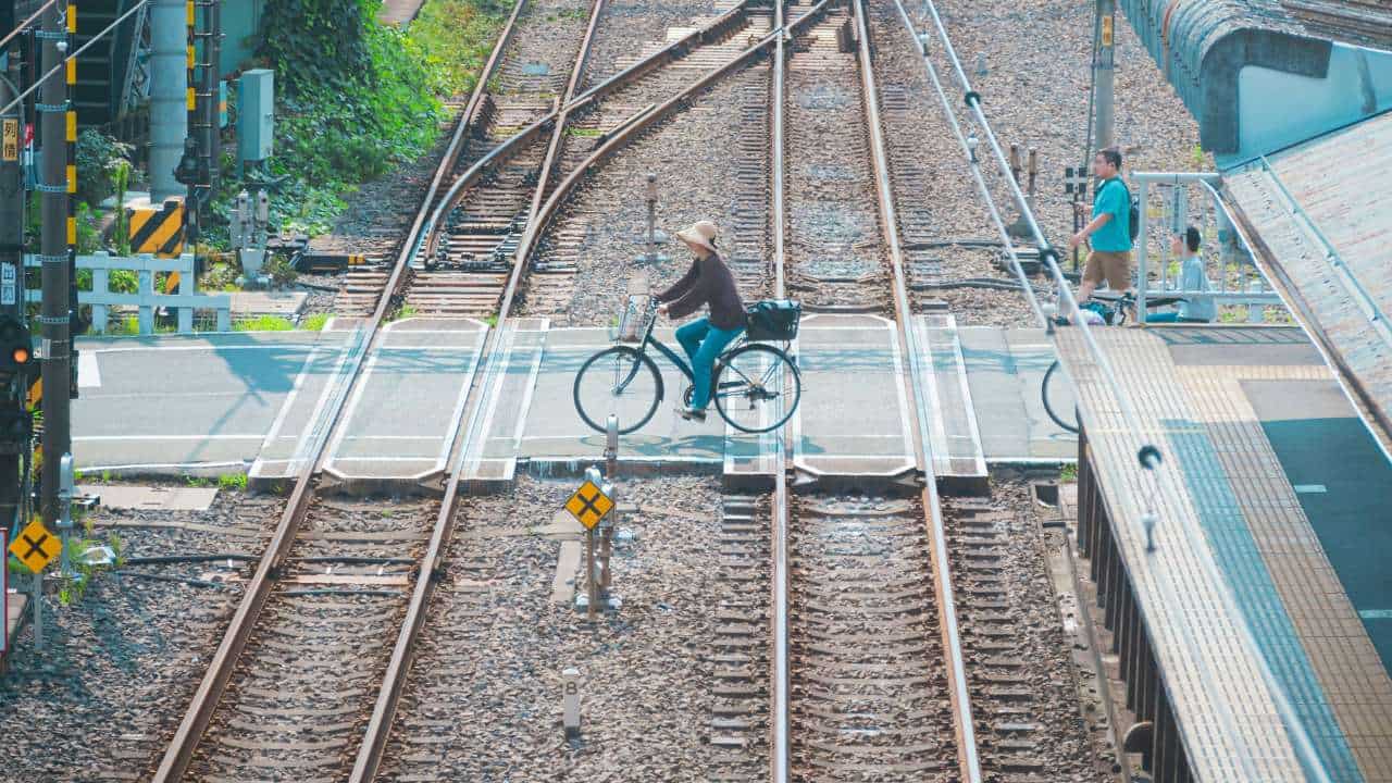 Person bikes through level crossing