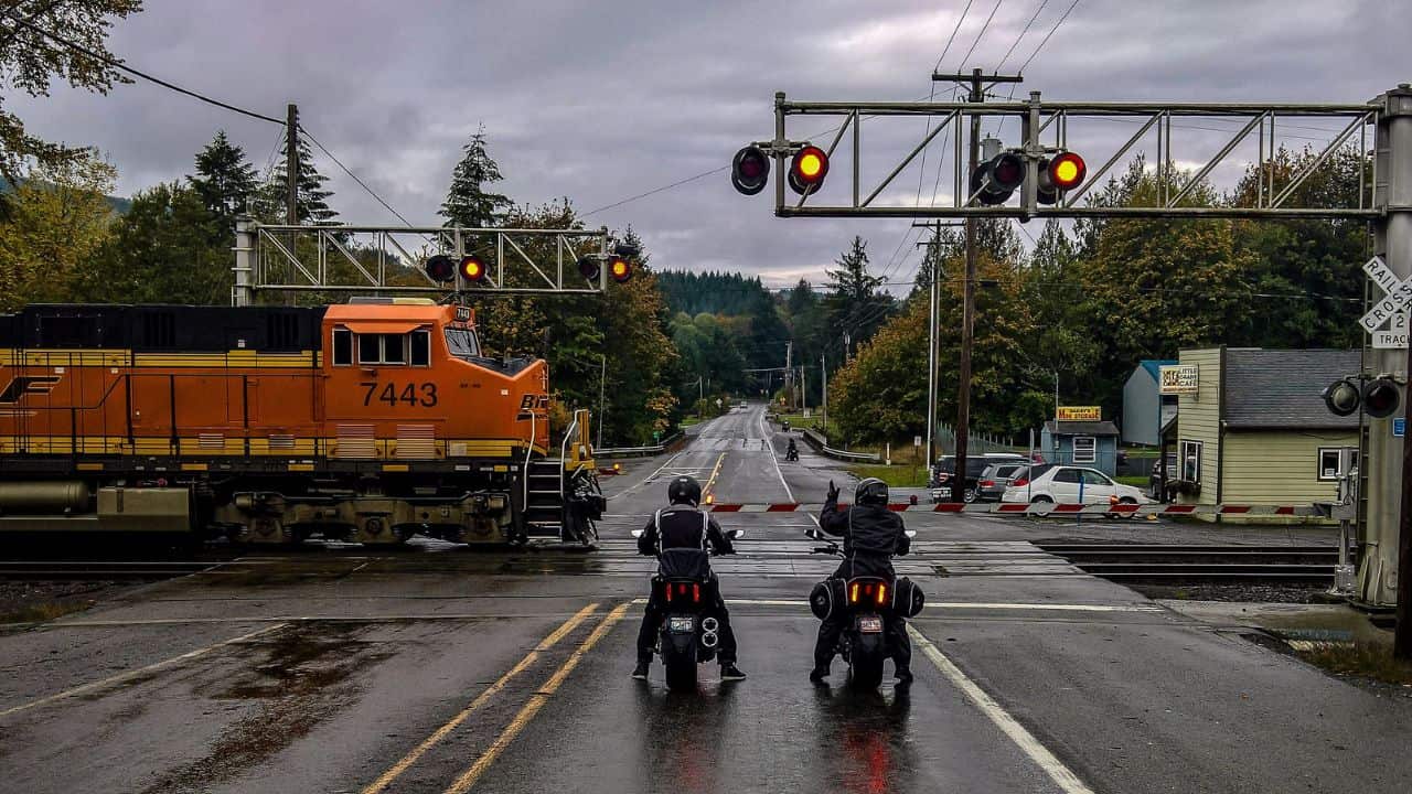 Two motor bikes waiting at level crossing light