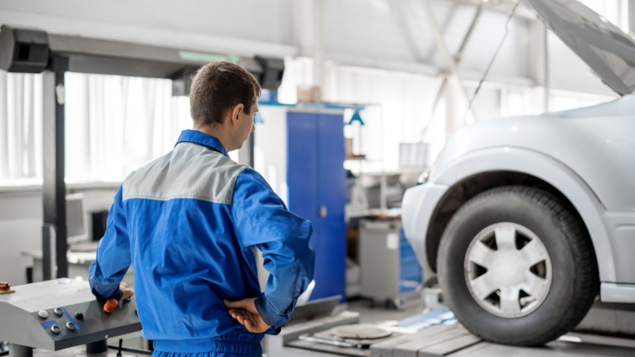 MOT Technician Looking at Car