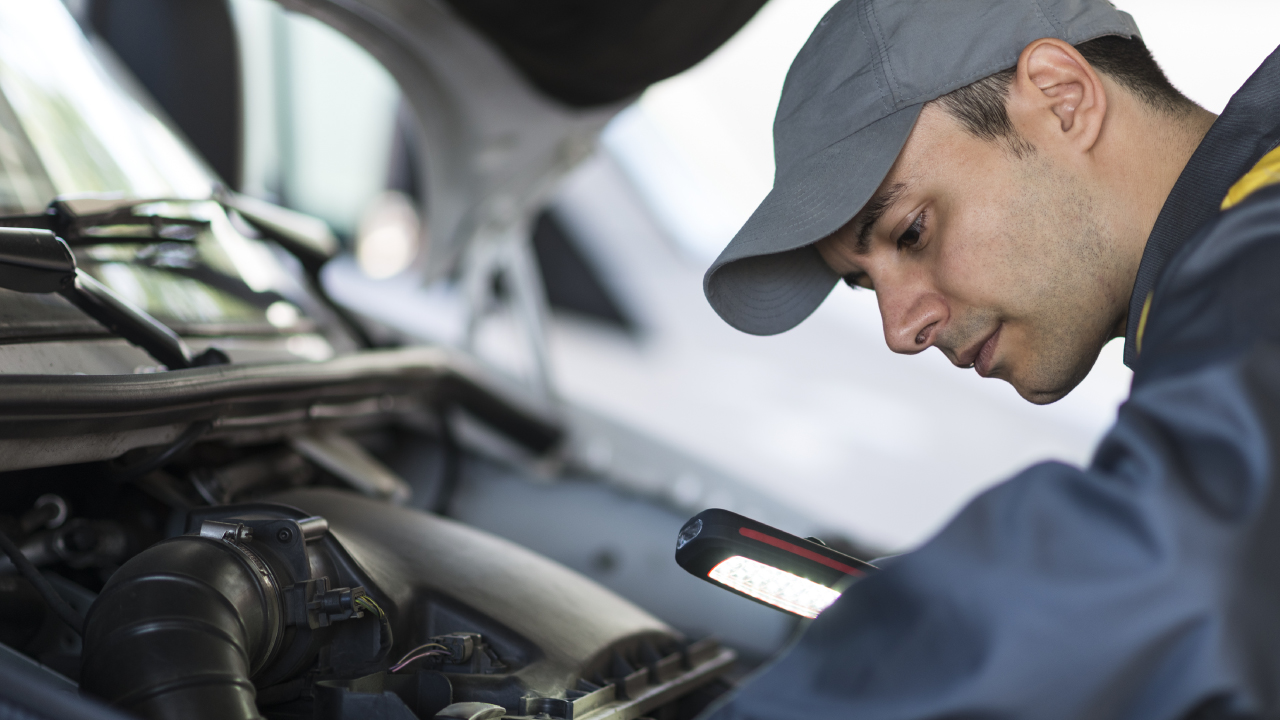 Mechanic Looking Under Bonnet In Car