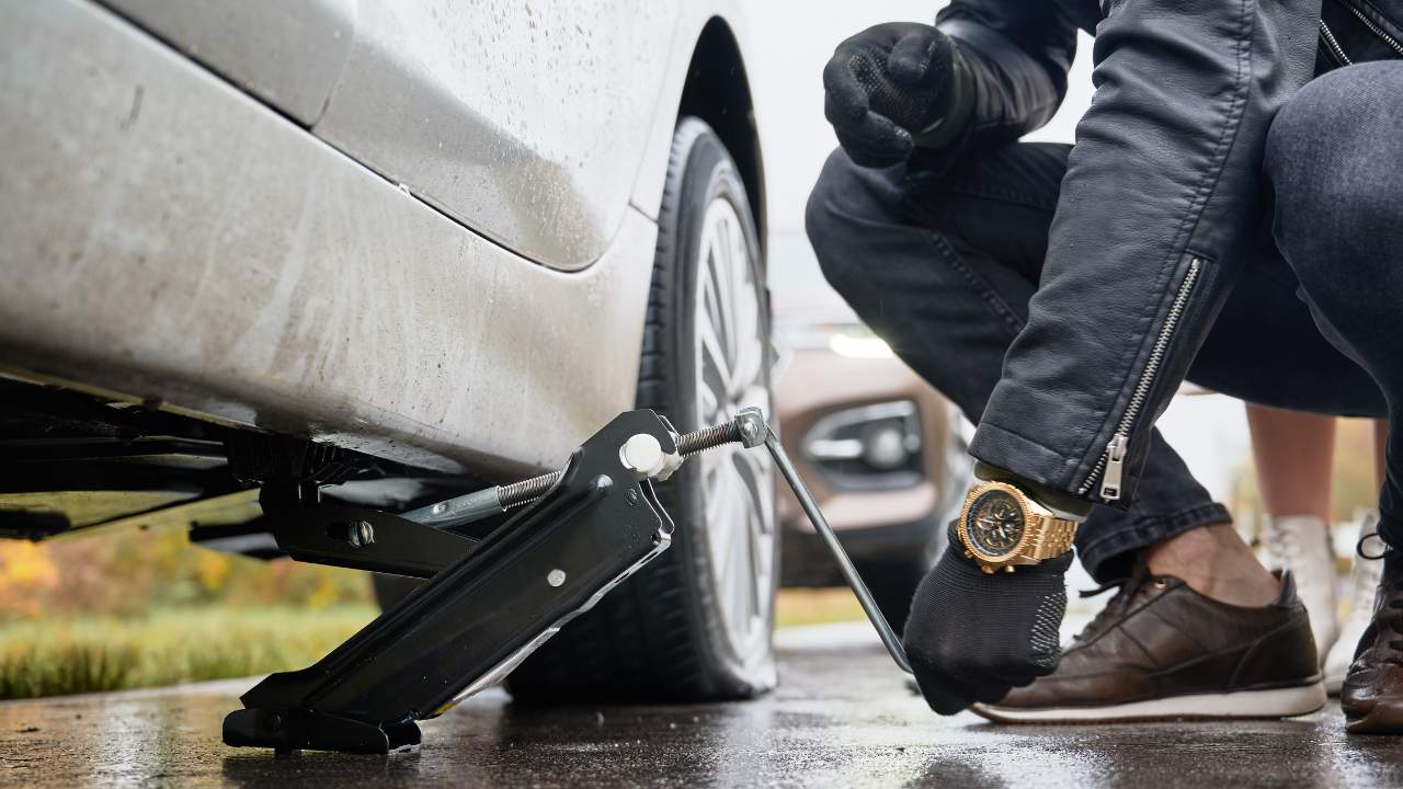 Man lifting car using tool