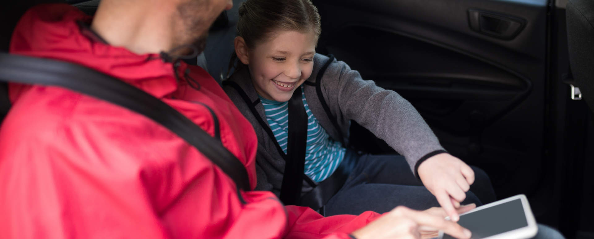 Child with Seatbelt on Playing with iPad