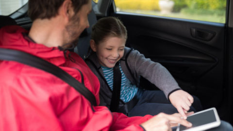 Child with Seatbelt on Playing with iPad