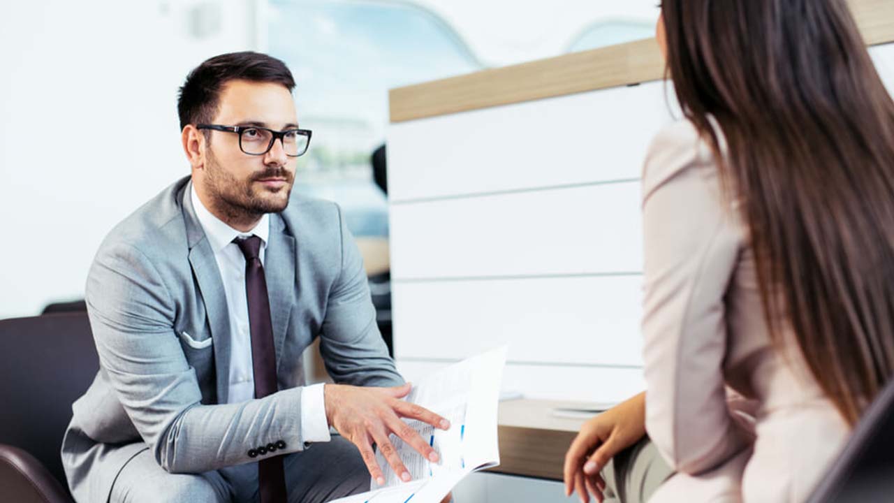 Man and Woman Talking in a Car Dealership