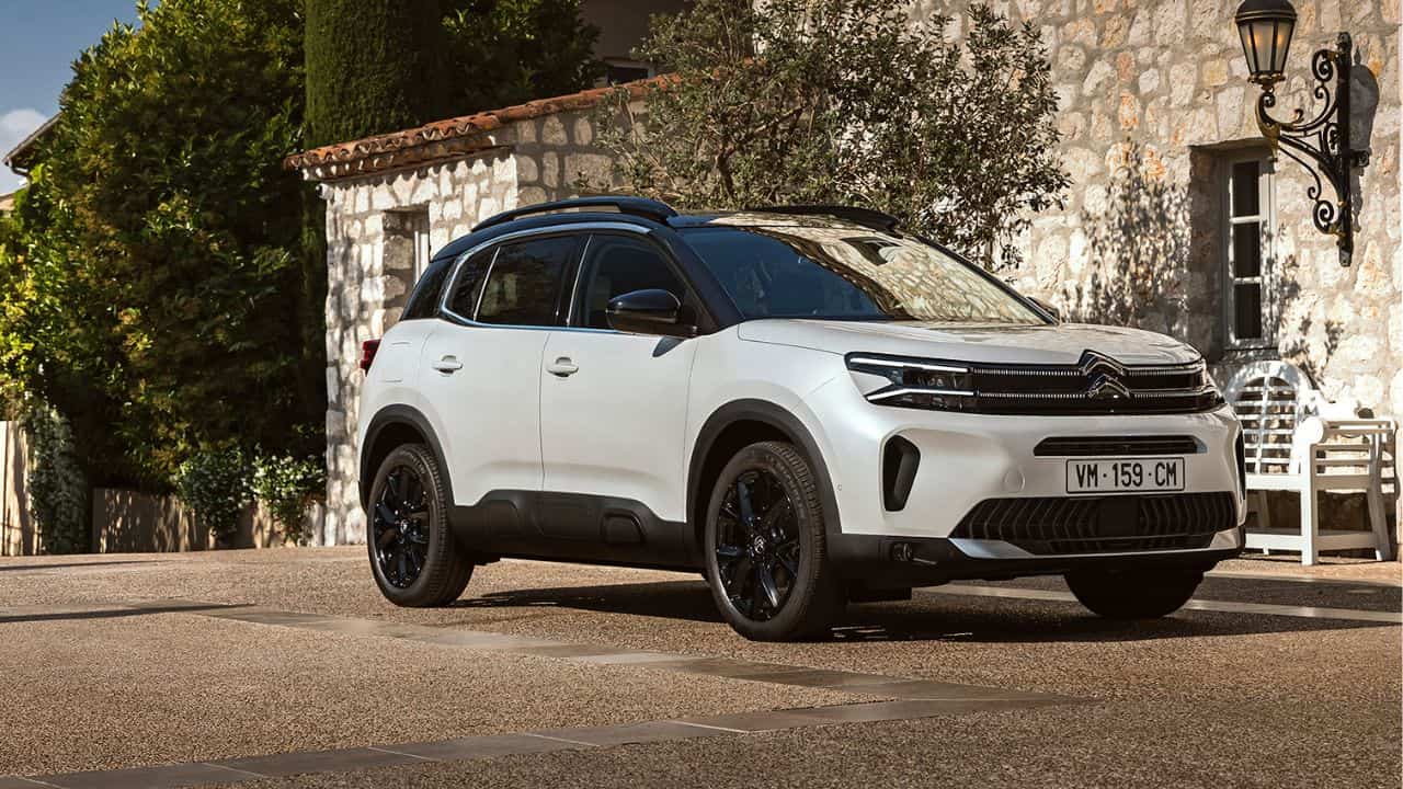 White Citroen C5 Aircross parked in front of a stone house