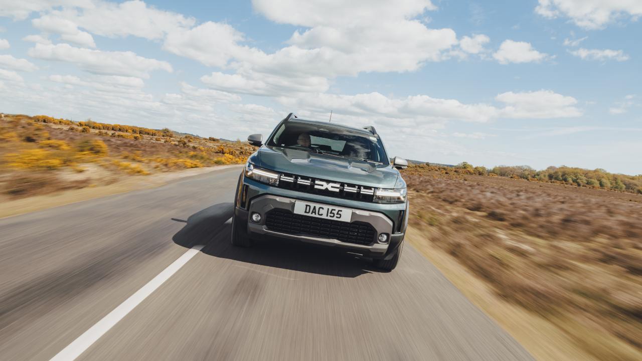 Front view of a Dacia Duster driving on a rural country road