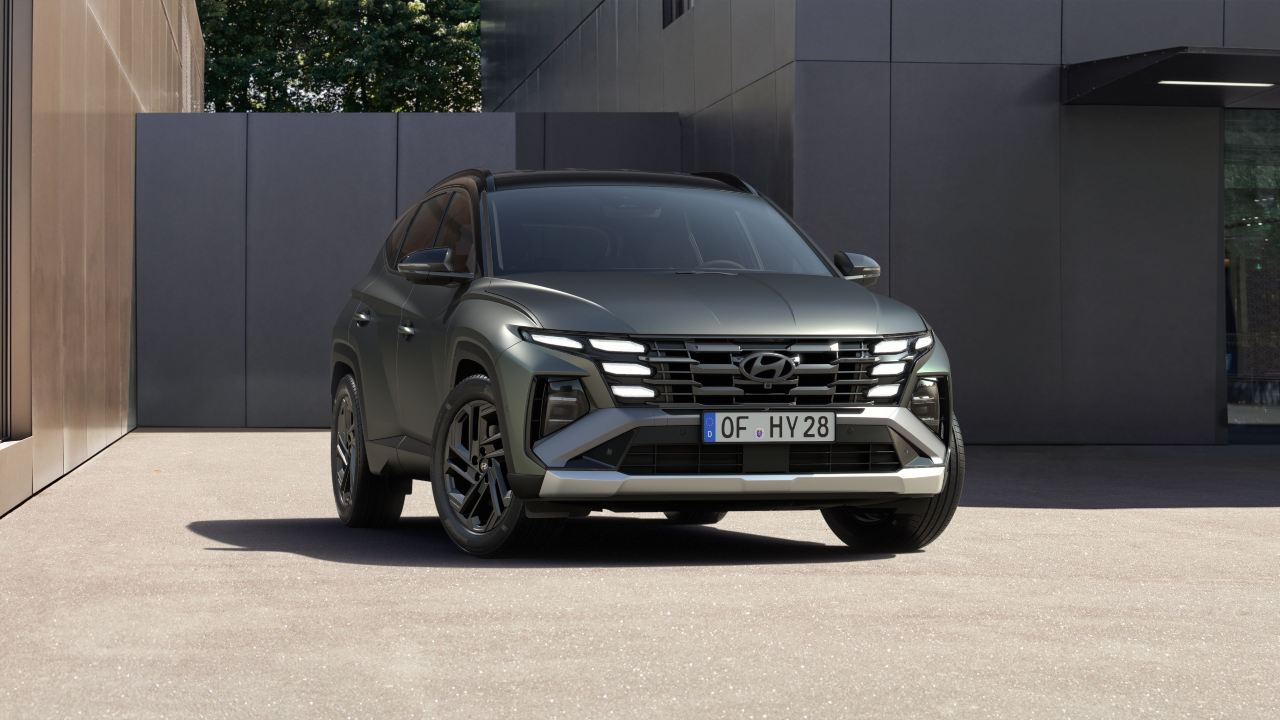 Front three-quarter view of a Hyundai Tucson parked in a contemporary urban setting