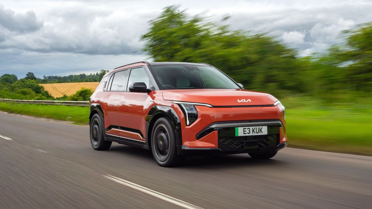 Kia EV3 driving on a countryside road showcasing its modern electric SUV design