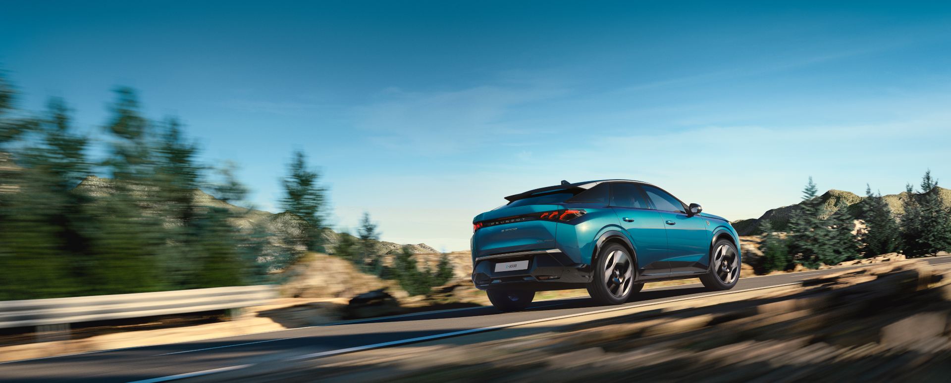 Rear three-quarter view of a Peugeot E-3008 driving along a scenic mountain road
