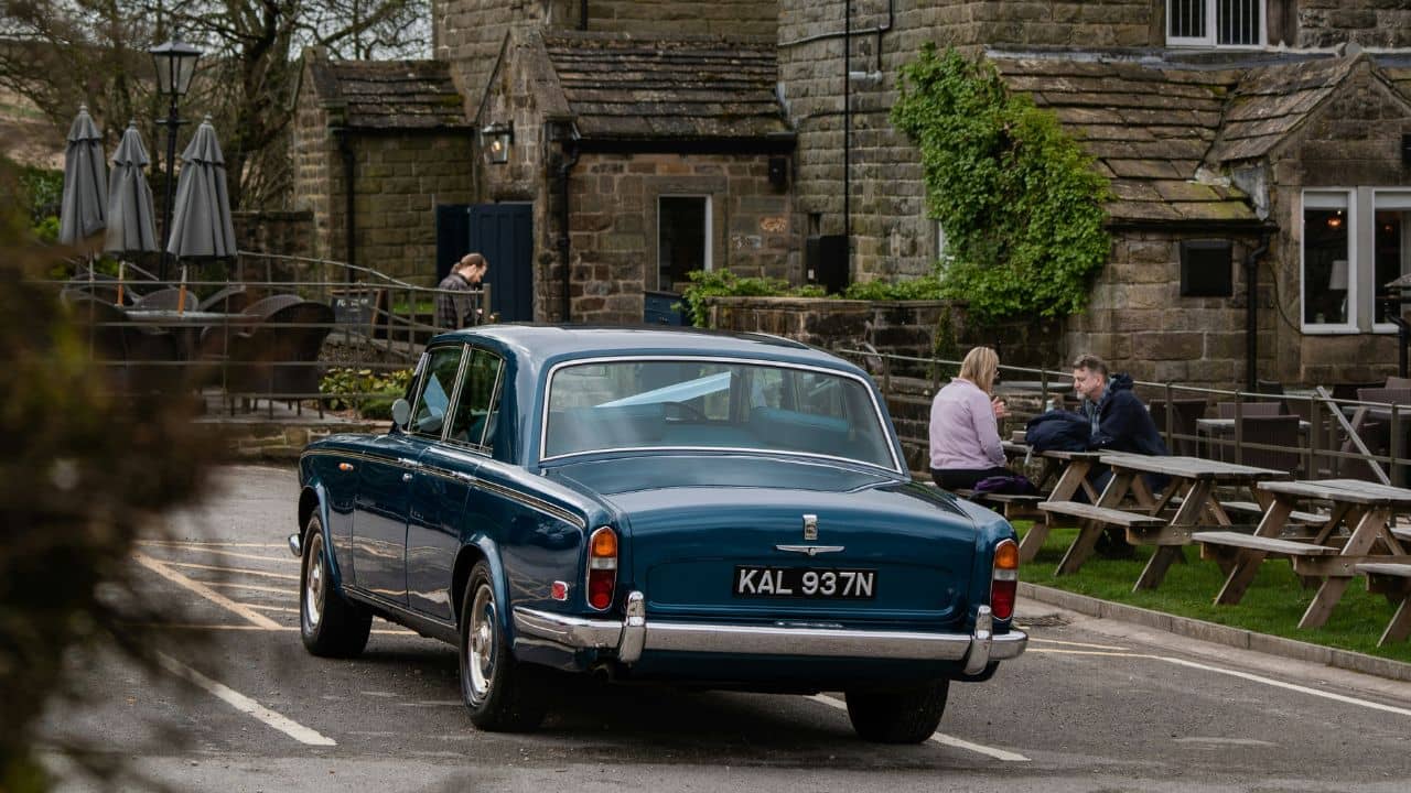Blue car driving in a British village