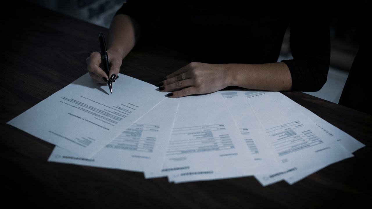 Woman signing multiple contracts