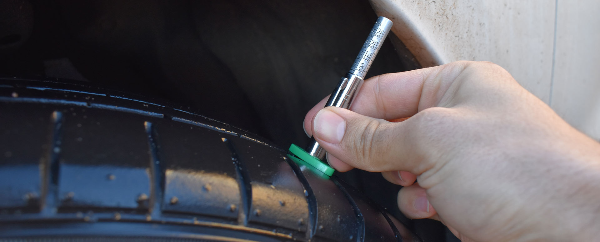 motorist checking tyre tread depth