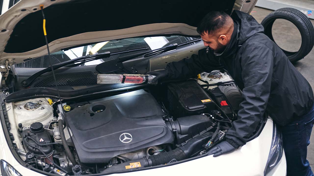 Technician inspecting a car's engine bay