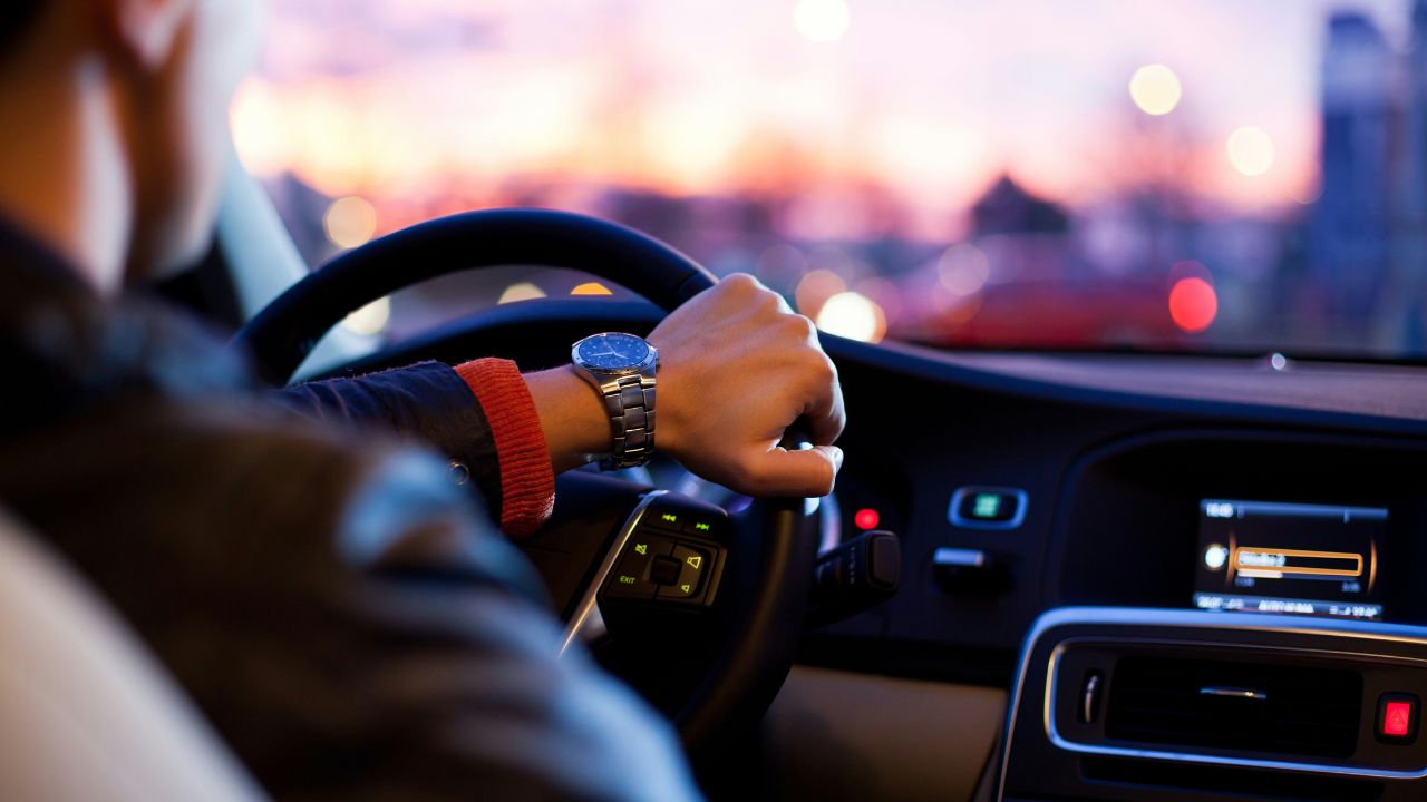 Man wearing a fancy watch driving a car in the city