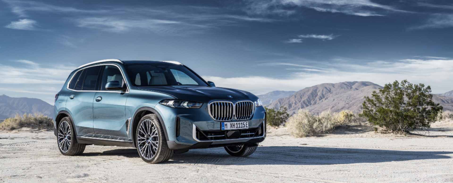 Blue BMW X5 front right mountain range