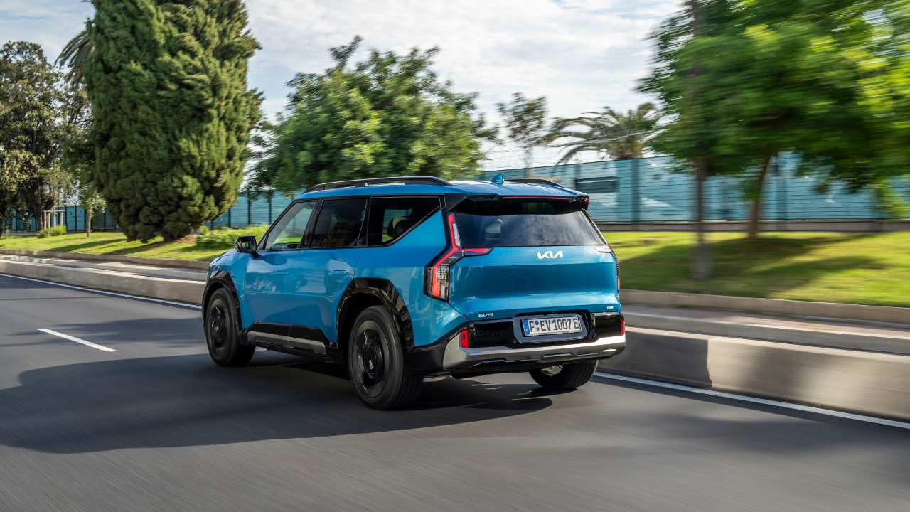 KIA EV9 driving rear angle blue