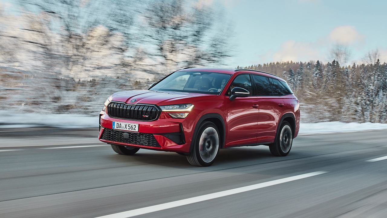 Red Skoda Kodiaq driving snowy background 