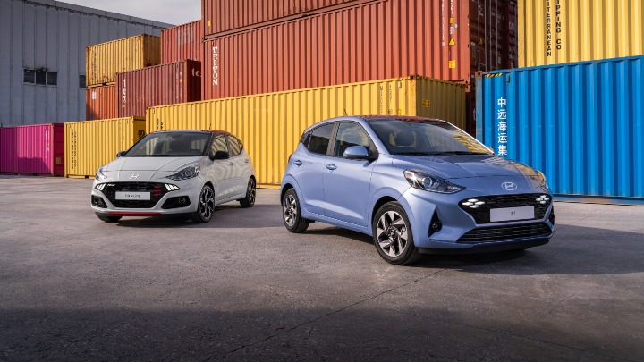 Blue Hyundai i10 pair front with shipping containers behind
