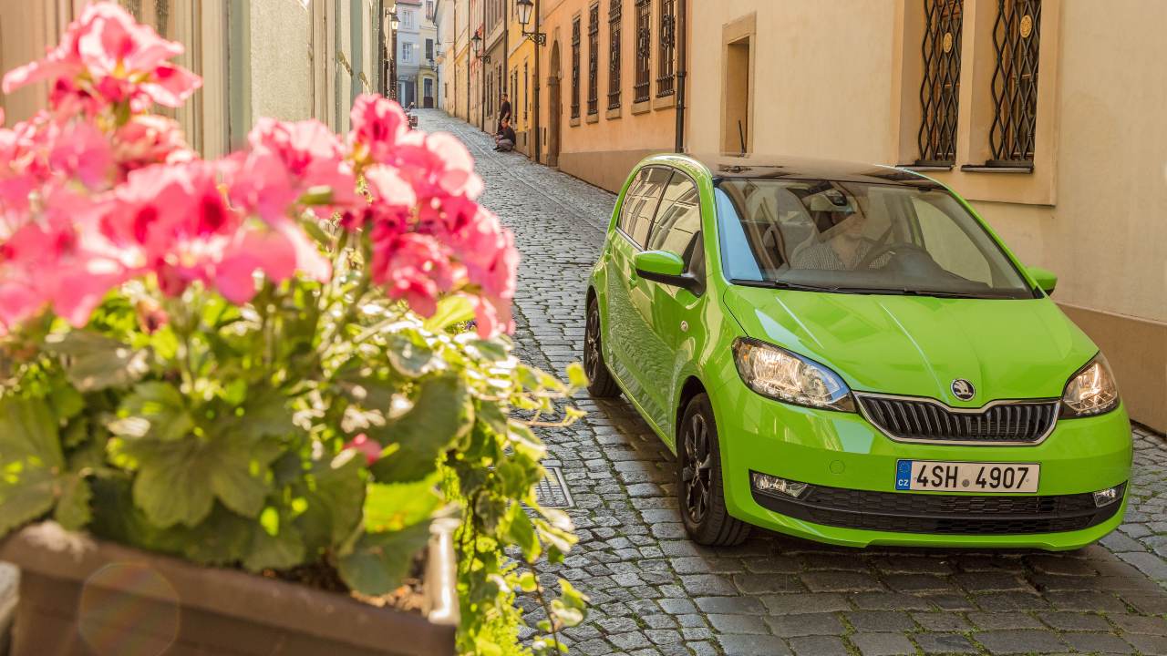 Skoda Citigo bright green on street with flowers
