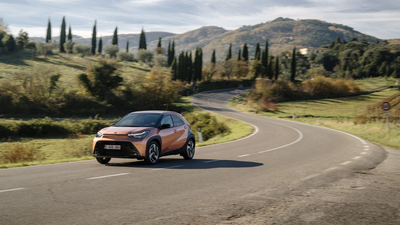 Bronze Toyota Aygo X driving 