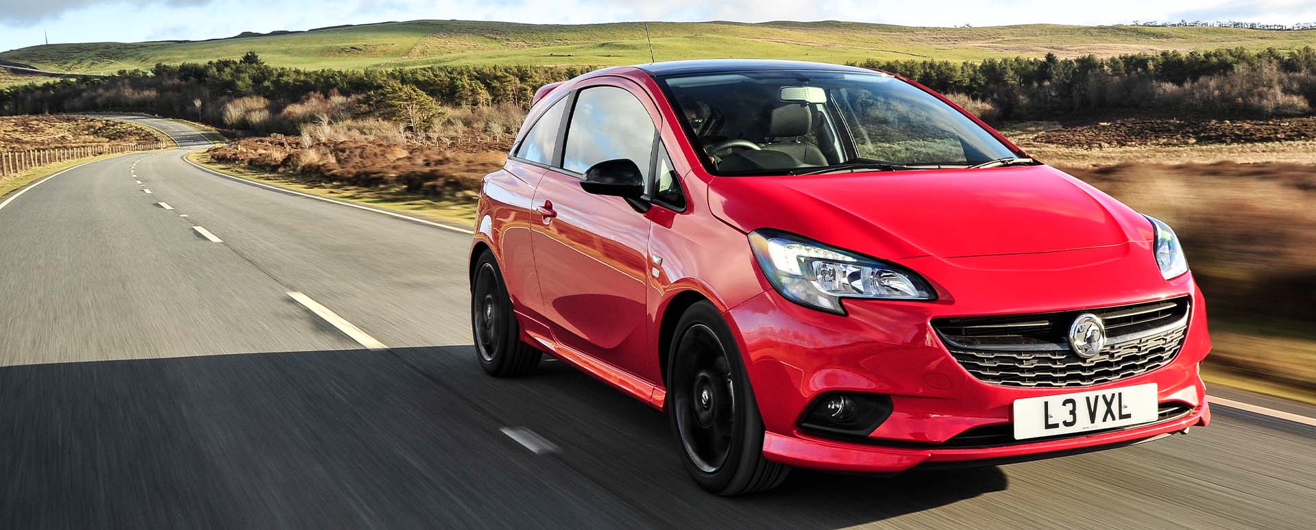 Red Vauxhall Corsa, driving in countryside