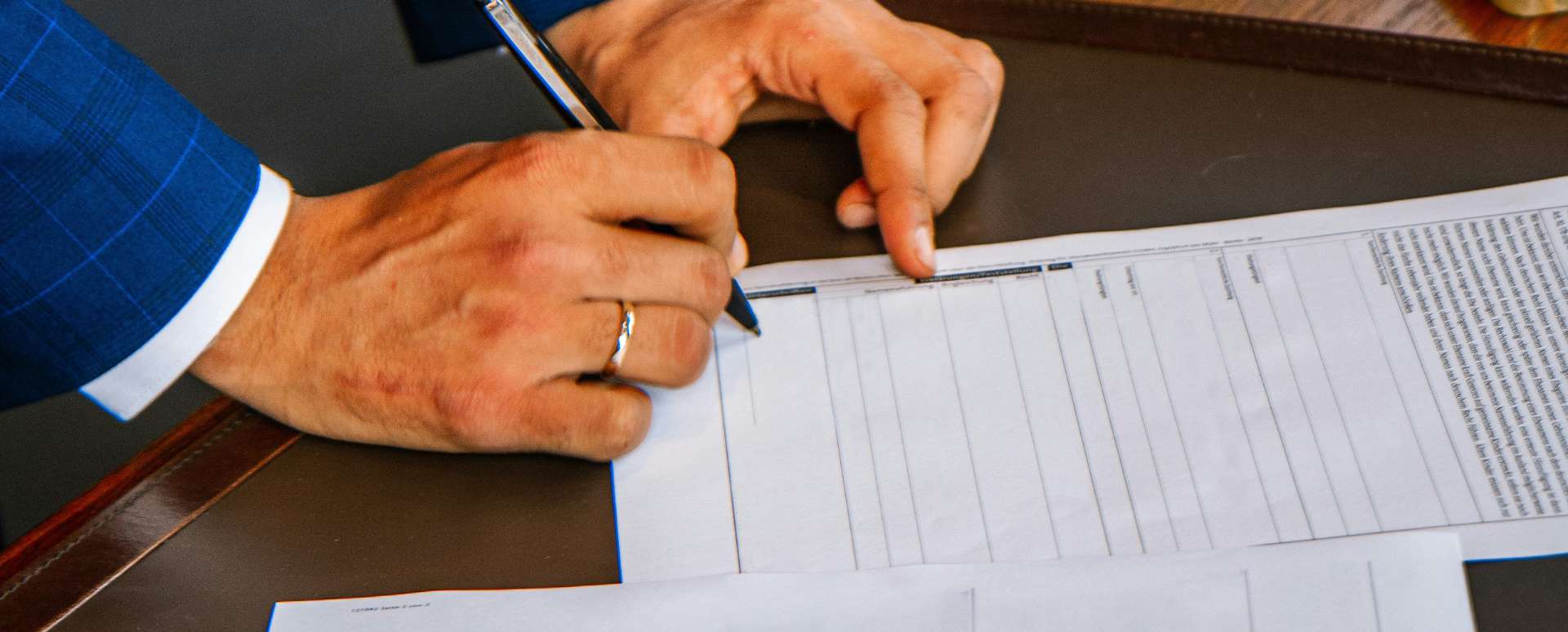 Man signing a contract on a table