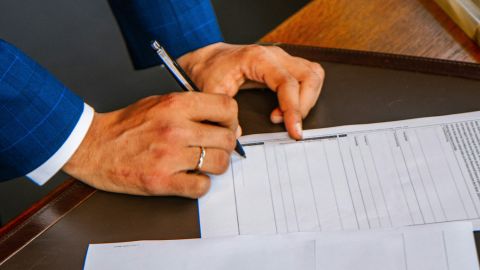 Man signing a contract on a table