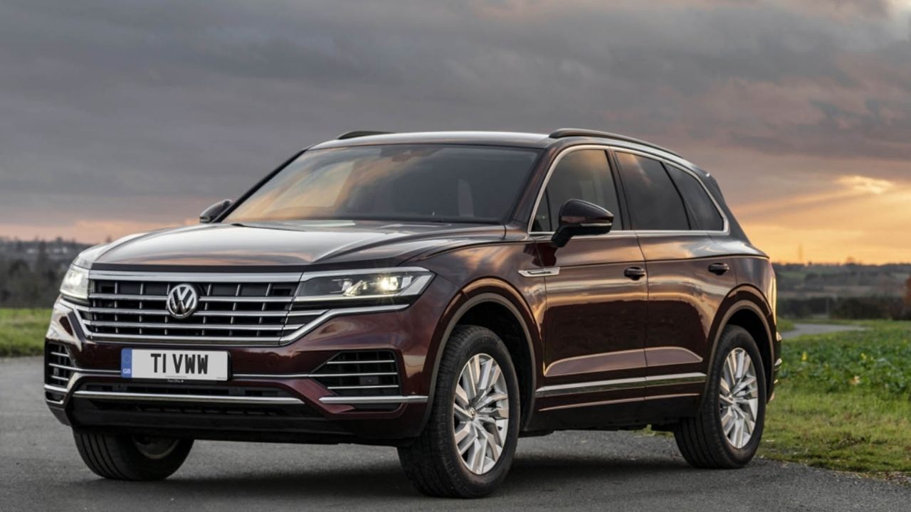 Burgundy Volkswagen Touareg parked on a road in the country side