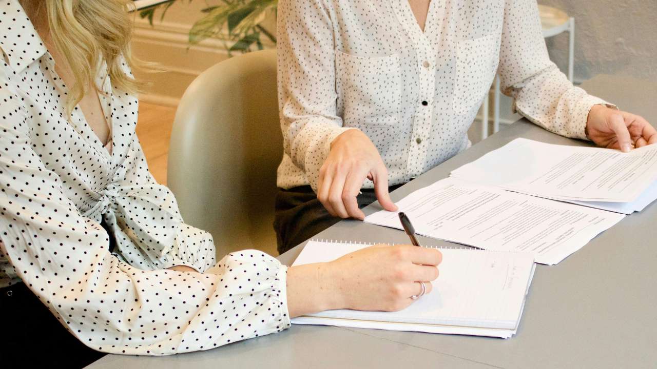 Two women signing a contract