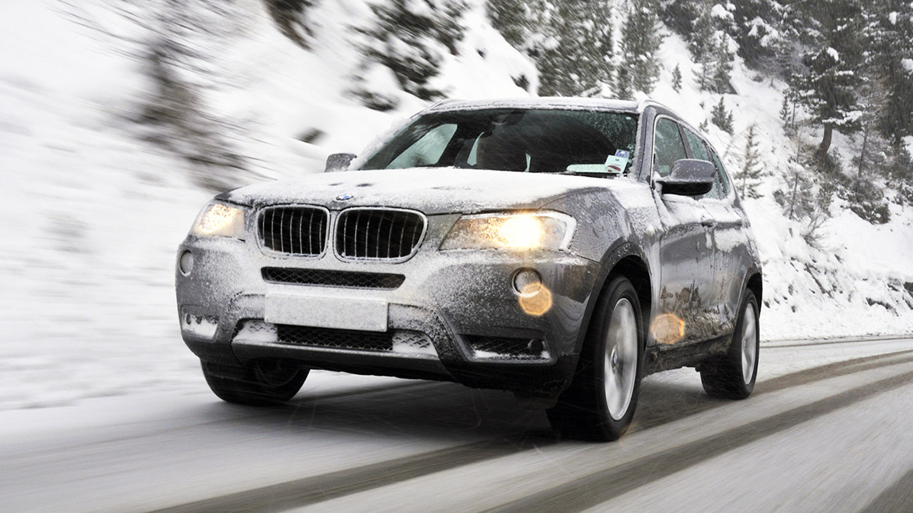 BMW X1 driving on a snow covered road
