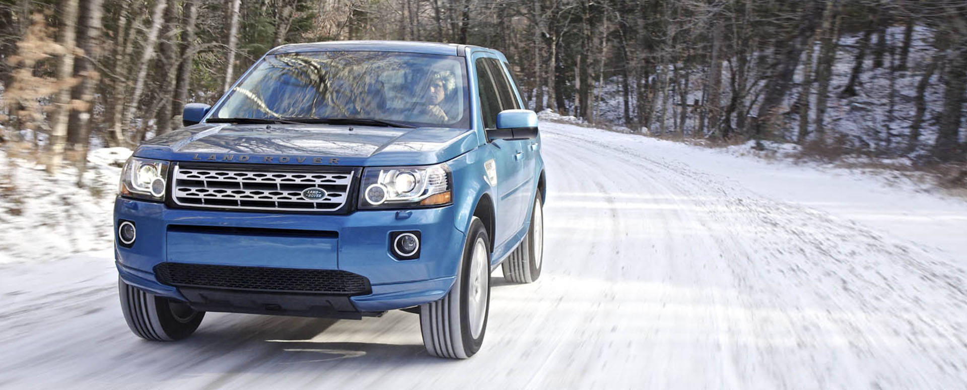 Blue Land Rover Freeland driving on snowy road