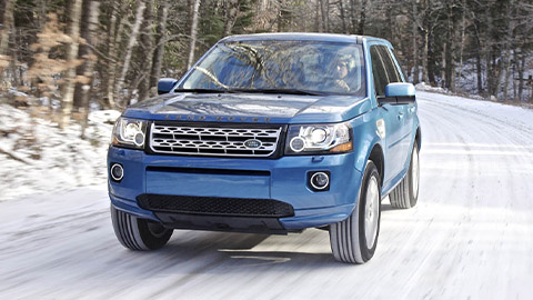 Blue Land Rover Freeland driving on snowy road