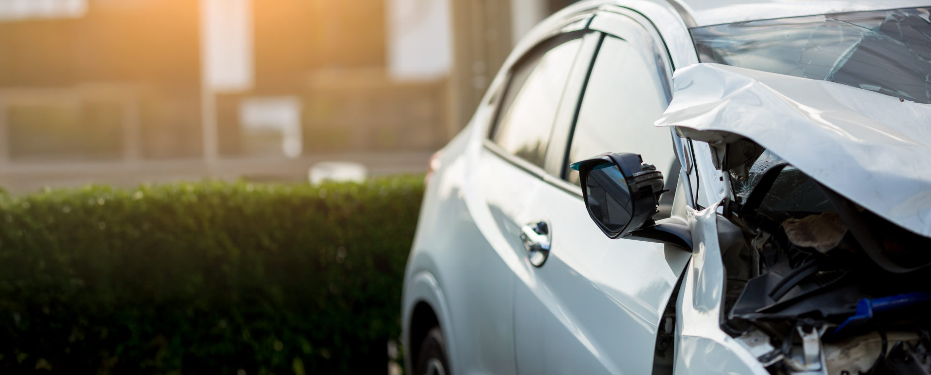 Half Of Silver Car Showing Damaged Bonnet and Wing Mirror