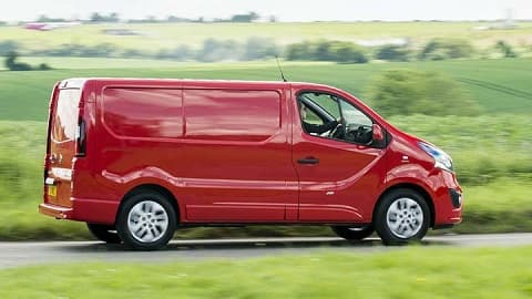 Red Vauxhall Vivaro, side shot, driving in the countryside