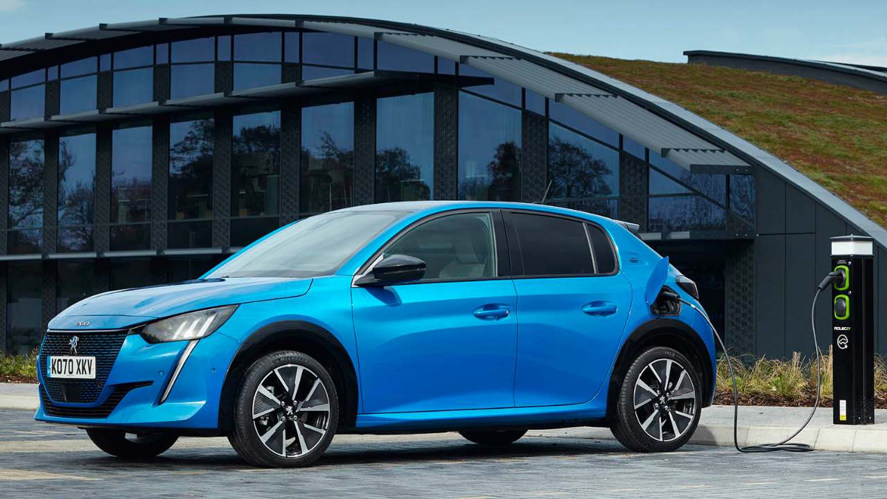 Blue Peugeot e208 parked in front of a curved glass building