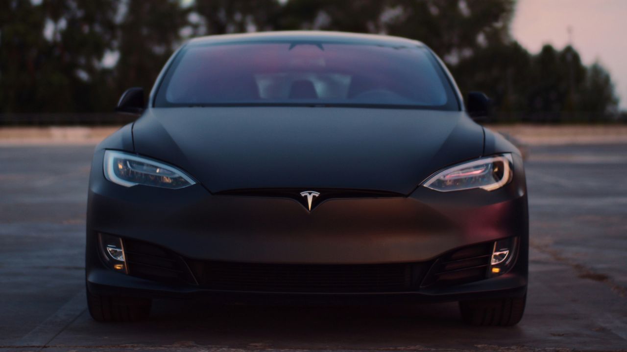 Front of a black Tesla that is parked in a carpark