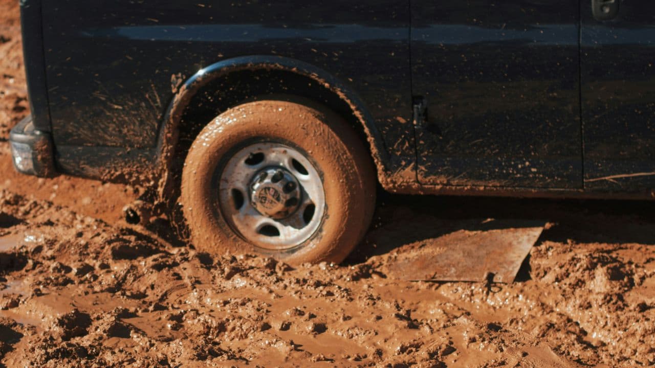 Wheel of a black vehicle stuck in the mud