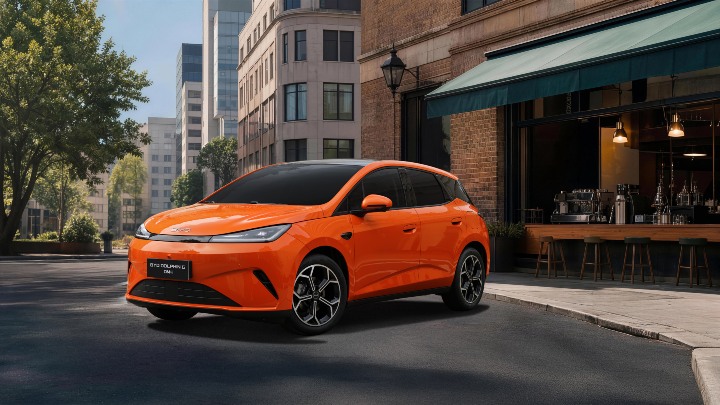 BYD Dolphin G DM‑i parked outside café on city street, orange hatchback