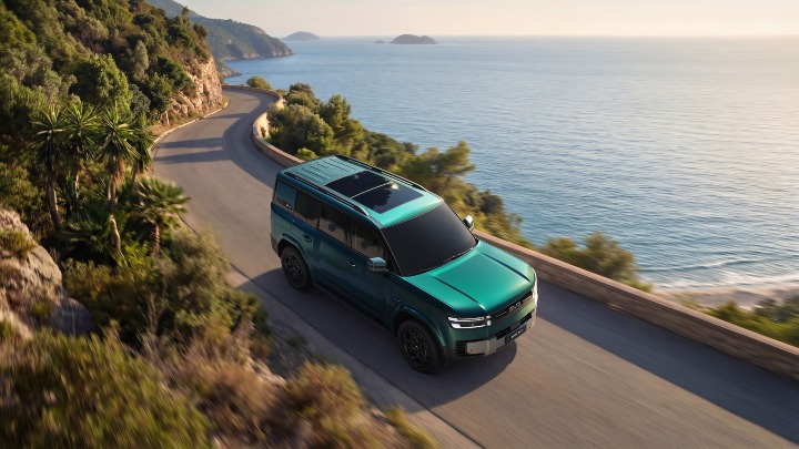 BYD Ti7 DM-p green aerial driving on coastal road