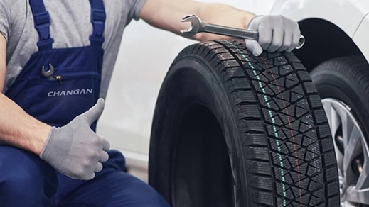 Changan technician inspecting a car tyre during vehicle servicing