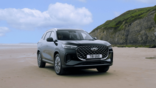 Black Chery Tiggo Vehicle Parked on Sand by a Cliff